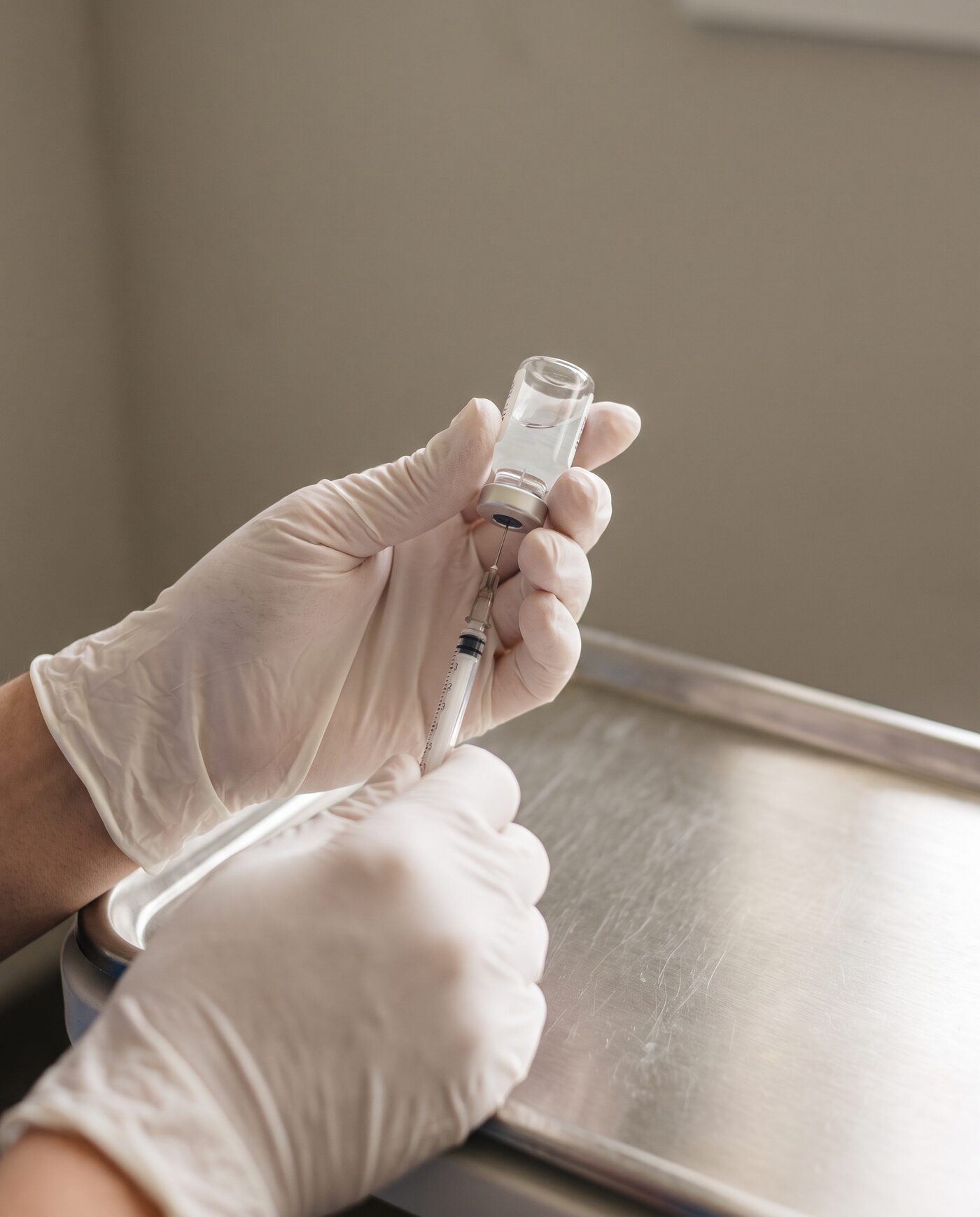 Behandschuhte Hände bereiten präzise eine ästhetisch-medizinische Behandlung vor