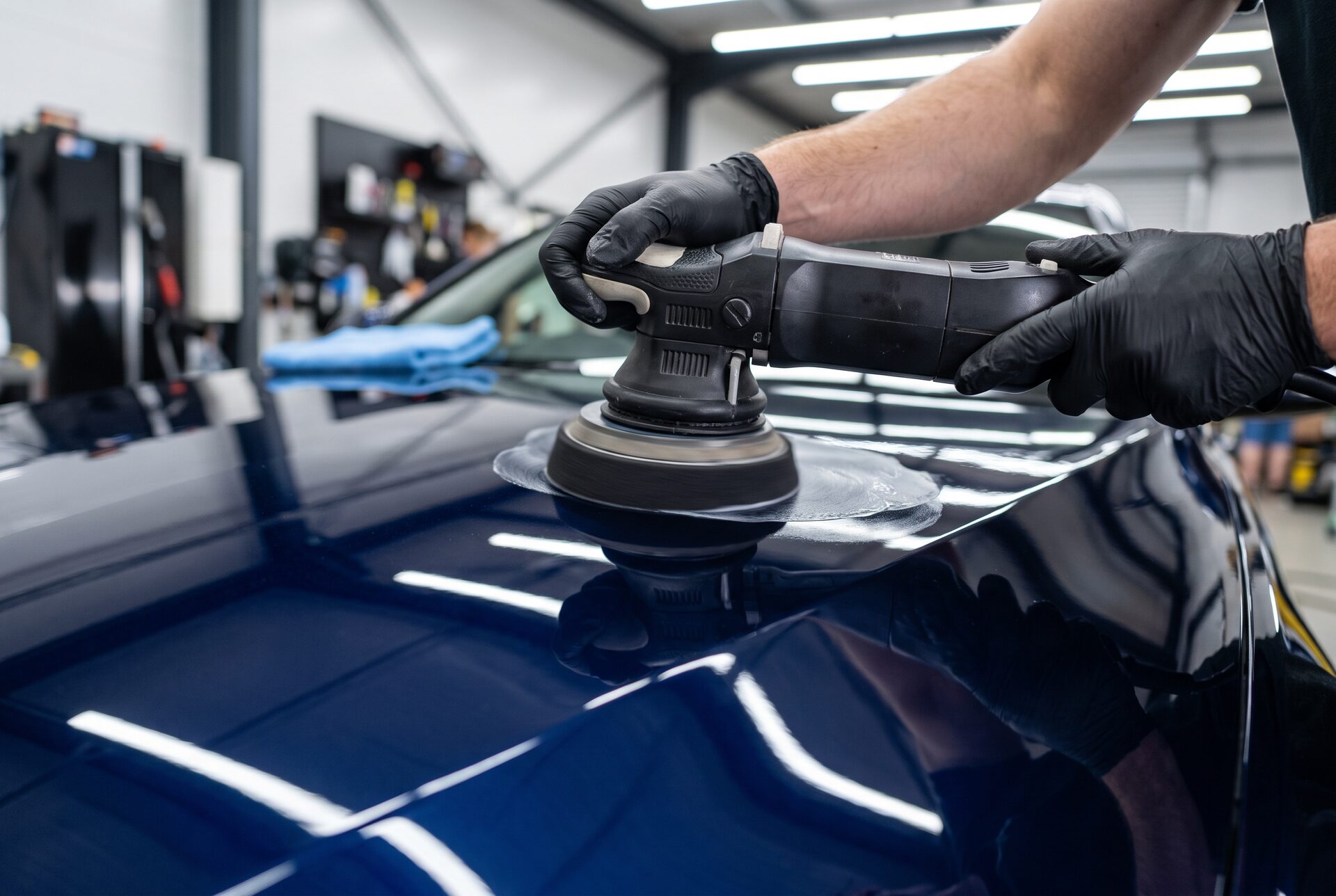 Poliermaschine arbeitet an einem Fahrzeugpanel mit makellosem Finish