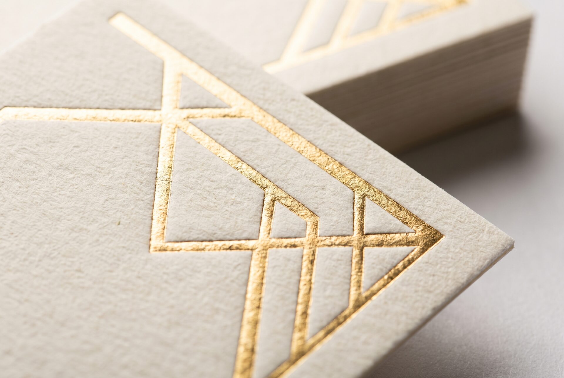 Makroaufnahme einer Goldfolienprägung auf dickem Baumwollpapier