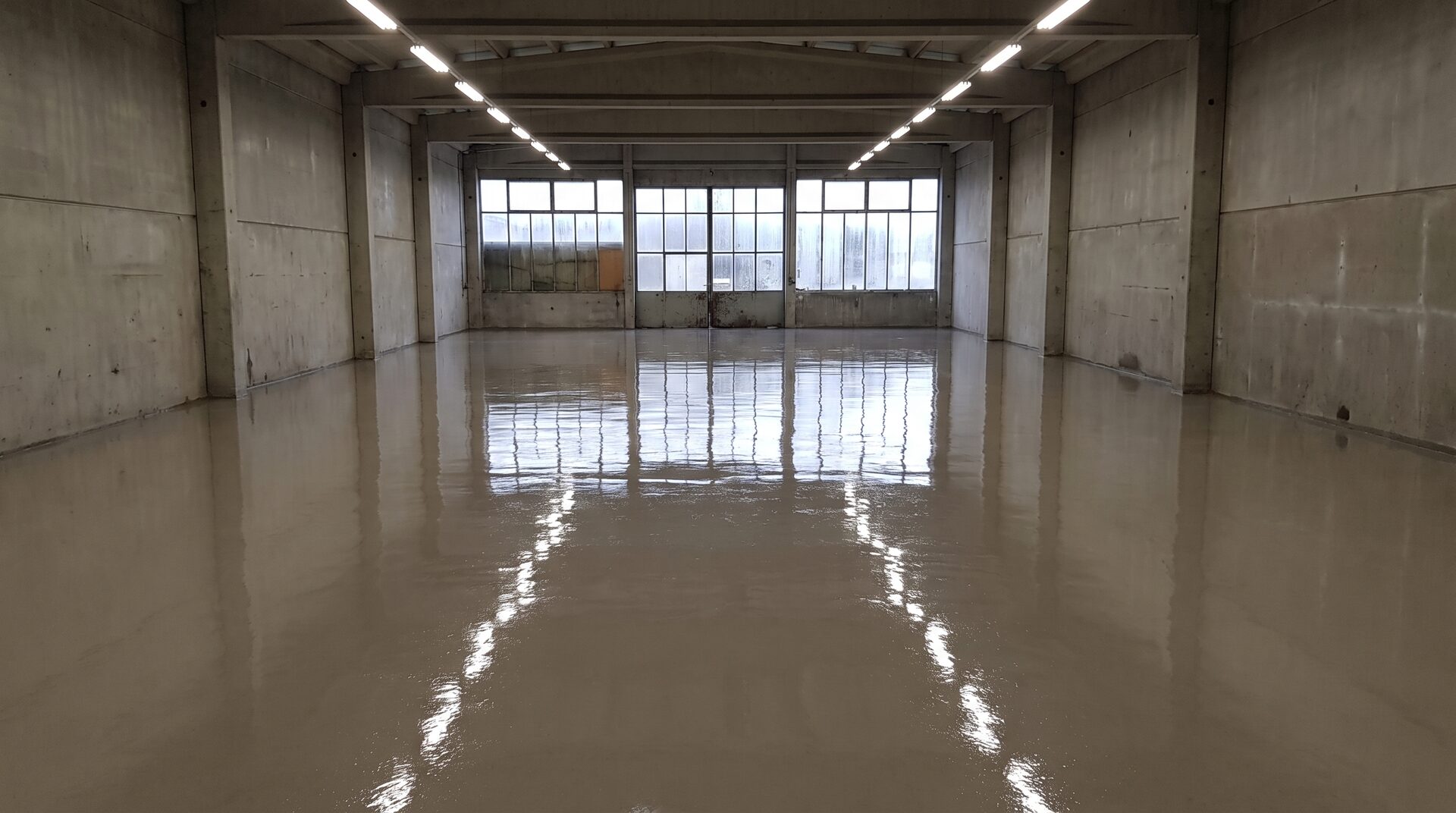 UNTERGRUND – grosser leerer Raum mit frisch gegossenem Fliessestrich