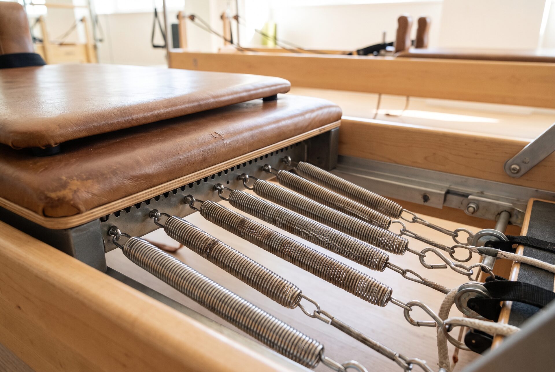 Detail eines Pilates-Reformers mit Federn und Schlitten