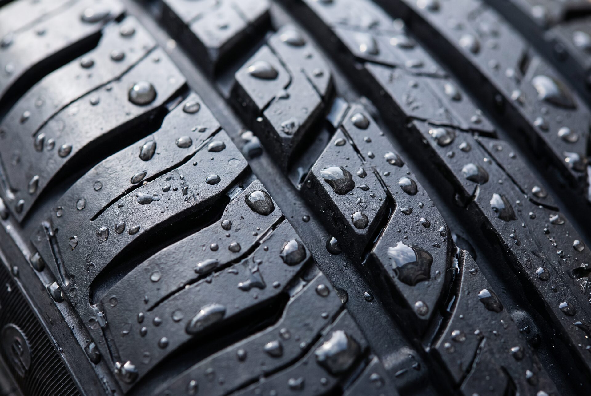 Makroaufnahme eines neuen Reifenprofils mit Wassertropfen