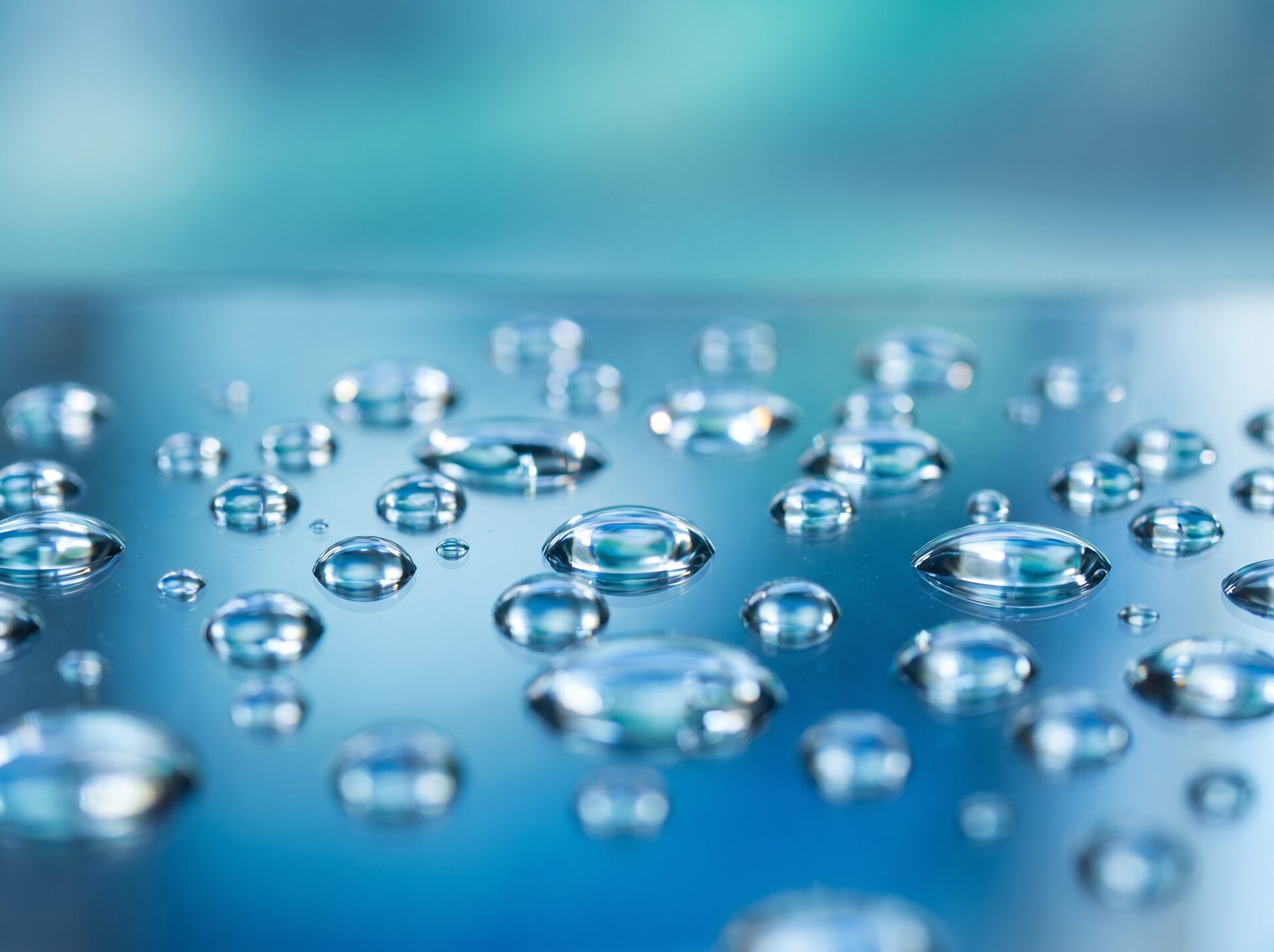 Nahaufnahme einer frisch gereinigten, spiegelnden Oberfläche mit glänzenden Wassertropfen